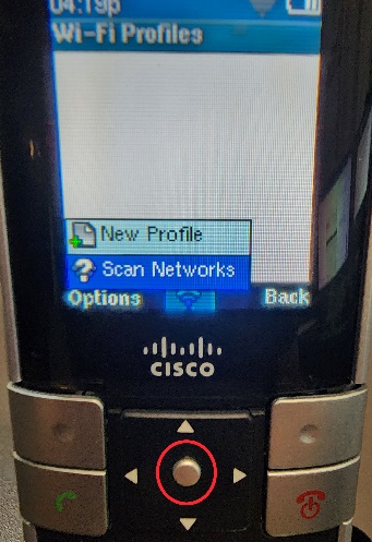 Picture of the Cisco WIP310 cordless phone with a circle highlighting the Select button, but also showing the Scan Networks menu option being highlighted